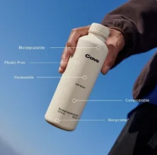 Hand holding a clear bottle against a blue sky with callout labels